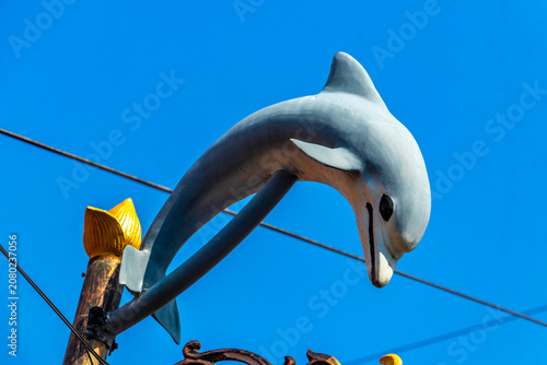 Golden green white street lantern with ornate dolphin figure in Thailand.