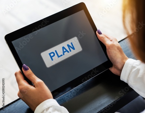 Woman holding a digital tablet with the word plan on the screen