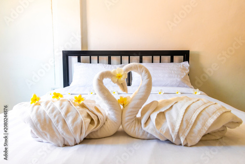 Luxury hotel bedroom swan towel romantic art vacation setup scene.