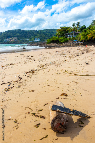 Dirty tropical beach covered by marine trash during rainy offseason weather Thailand.