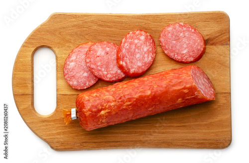 Salami sausage slices on a wooden board isolated on a white. Top view