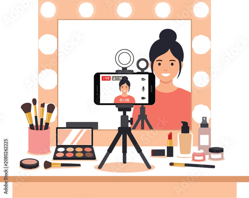 Woman records beauty vlog with accessories and makeup on table indoors