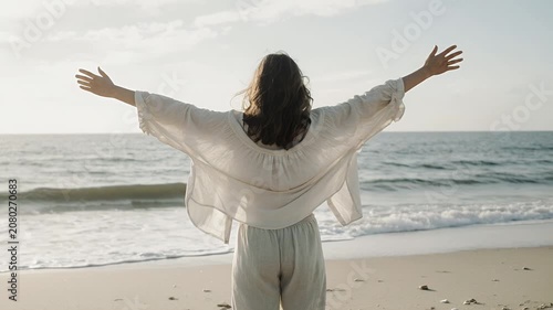 Woman Standing With Arms Raised Facing Ocean Beach Lifestyle Video
