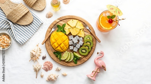 Fresh tropical fruit platter and summer drink on white background