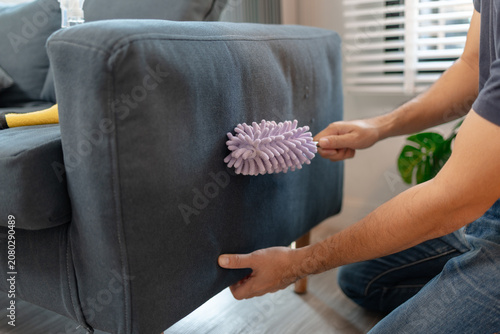 Billede på lærred Professional home and office cleaning with disinfecting spray, wiping shelves, dusting furniture and sanitizing sofa surfaces to maintain a clean, organized and healthy indoor environment