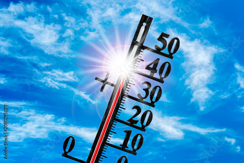 Auf einem Thermometer zeigt die Skala sehr hohe Temperatur um 40 Grad Celsius vor blauem Himmel mit strahlender Sonne - FOTOMONTAGE