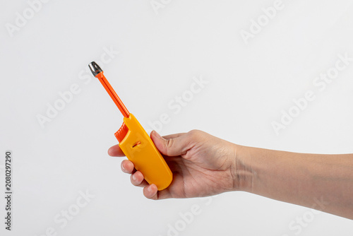 Quadro su tela Yellow gas lighter gun for gas-stove and hand isolated on white background