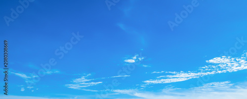 the sky is clear blue with fluffy white clouds, the sky is very bright, and the sun shines.