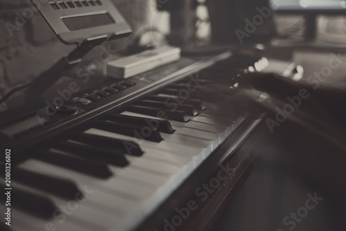 Foto The Nocturnes — Cinematic abstract of a musician hand moving over a piano keyboard in a dark late-night studio workspace, long exposure motion blur texture with moody warm copper lamp lighting