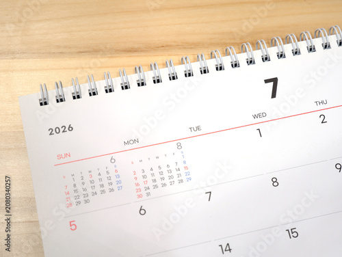 2026 calendar, July 2026 desk calendar placed on a wooden desk, 2026 New Year's resolutions.