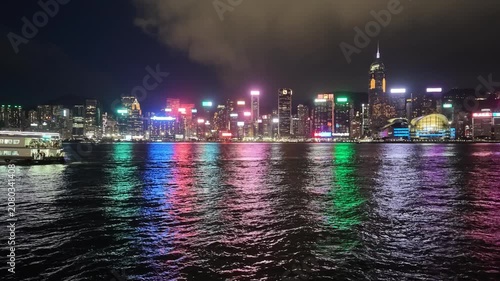 A sweeping night view of Hong Kong's iconic skyline and the vibrant urban landscape set against the dark waters of Victoria Harbour
