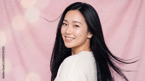 Beautiful Asian Woman Smiling on Pink Background Youthful Beauty and Natural Elegance