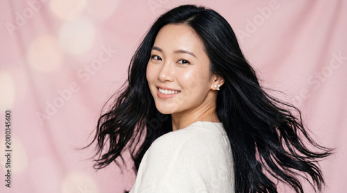 Beautiful Asian Woman Smiling on Pink Background Youthful Beauty and Natural Elegance
