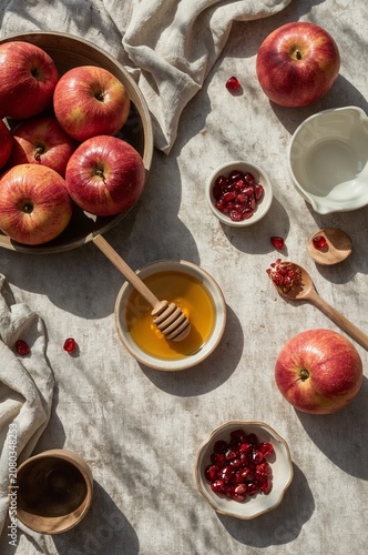 Delicious Red Apples, Honey, and Pomegranate Seeds Arranged on a Table During...