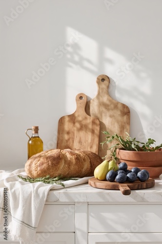 Fresh Bread and Fruits on a Kitchen Counter With Wooden Boards and Olive Oil