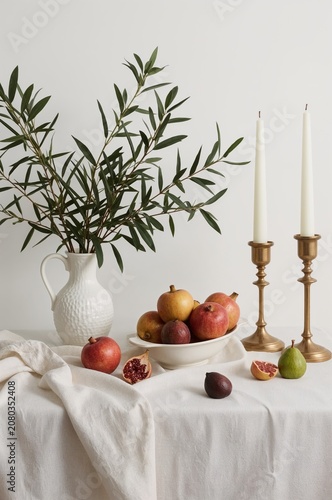 Display of Fruits and Candles on a Table With a White Cloth and a Plant in a ...