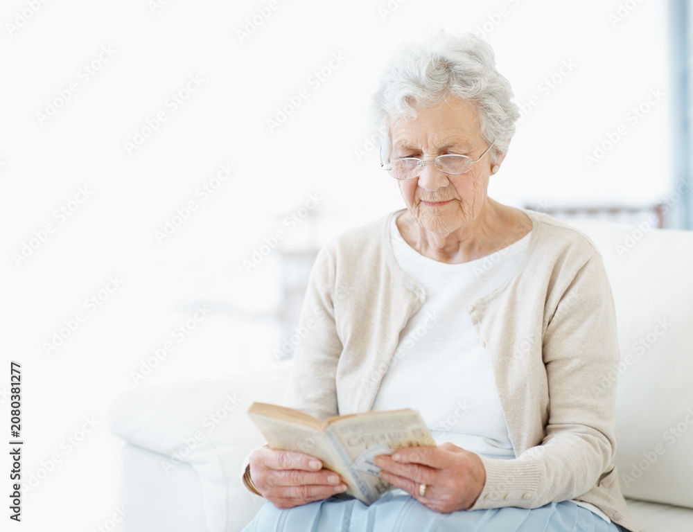 Obraz premium Calm, book or old woman on sofa with reading, fantasy novel or insight in literature hobby. Space, glasses or senior person in home with fairytale, peaceful moment or fiction story in retirement.