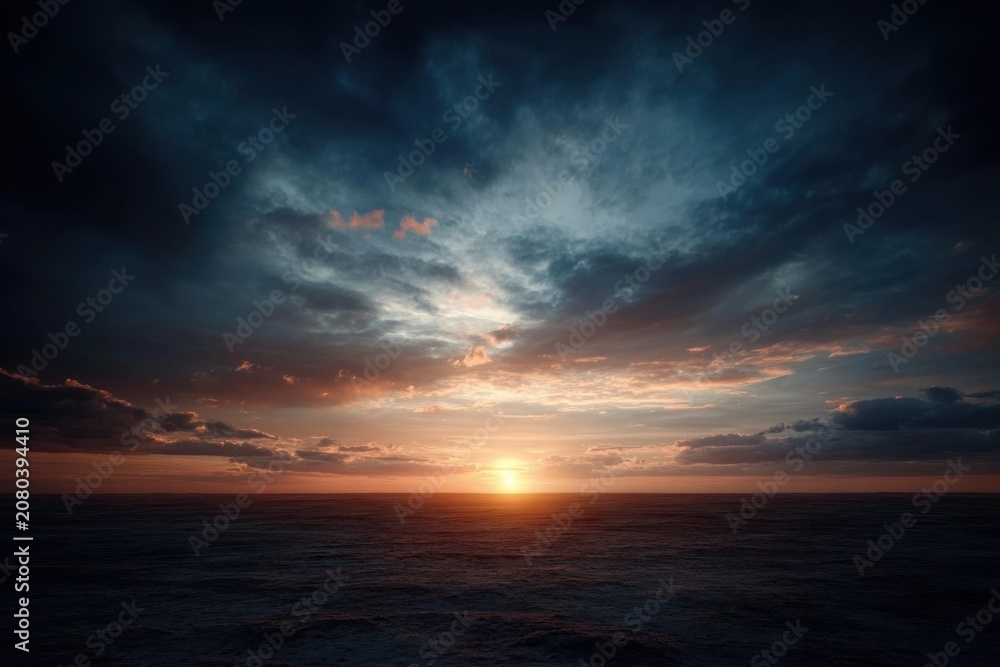 Obraz premium Stunning dramatic sunset over a calm ocean horizon.