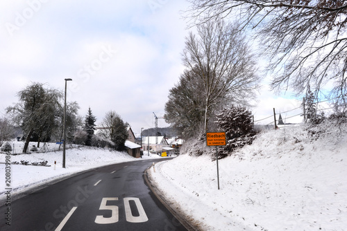 Fahrt auf der winterlichen Bundesstraße B290 bei der Ortseinfahrt nach Riedbach, Stadt Schrozberg in Baden-Württemberg