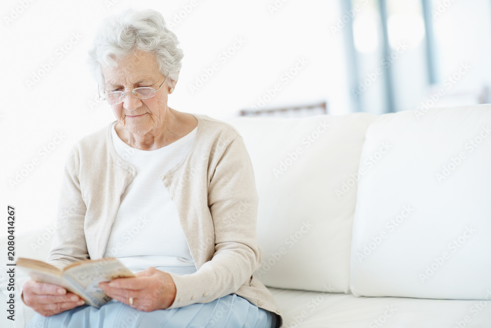Obraz premium Relax, book or old woman in lounge with reading, fantasy novel or insight in literature hobby. Chill, glasses or senior person in house with fairytale, peaceful moment or fiction story in retirement.