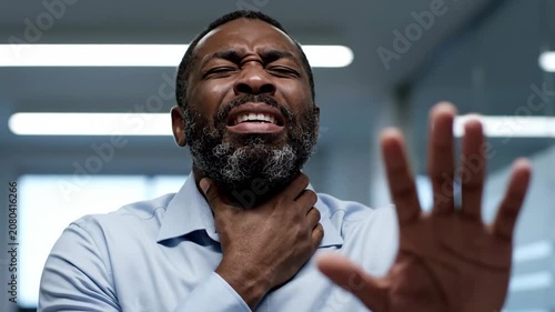 Man suffering from sore throat, holding his neck, and gesturing to stop, expressing discomfort and pain.
