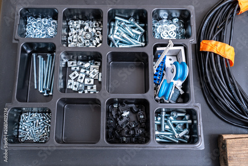 Tableau sur toile Top view of organized industrial hardware and fasteners in compartment tray