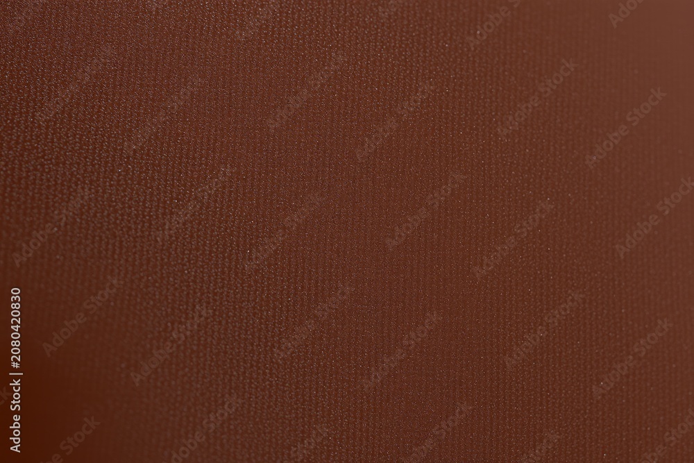 Fototapeta premium Rich brown texture dominates image. Subtle grain visible, suggesting material like leather or fabric. Warm tones present throughout.
