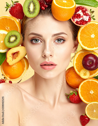 belleza femenina rodeada de cítricos y frutas frescas. retrato de mujer concepto de frescura, vitalidad, cuidado de la piel, bienestar natural y nutrición saludable
