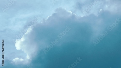 A serene sky scene with dynamic cloud movement across a clear blue backdrop.