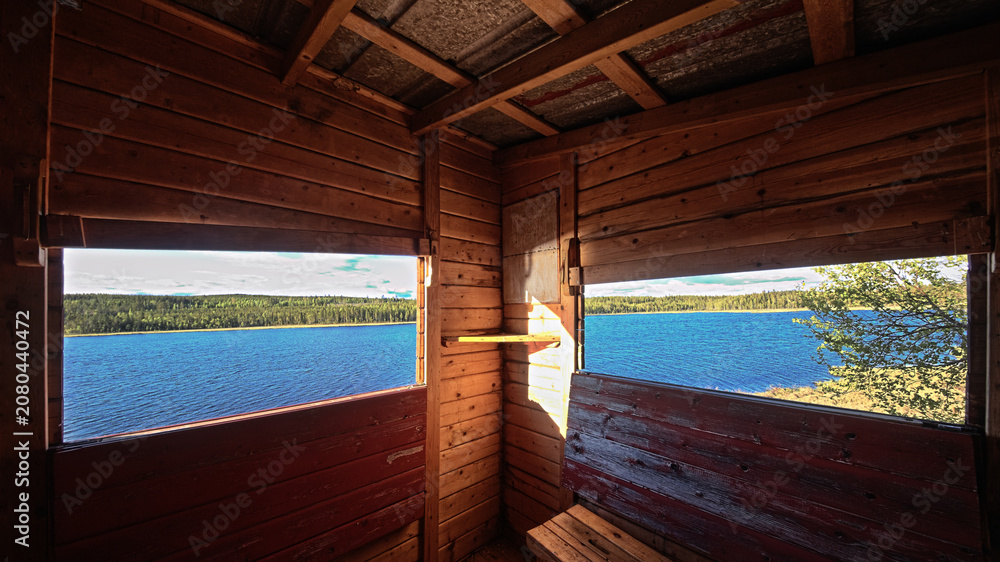 Fototapeta premium Wooden observation tower interior view through open windows across northern Swedish water