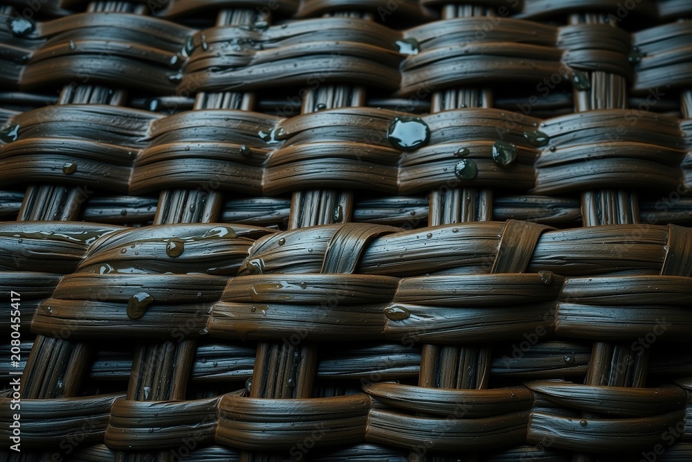 Obraz premium Woven texture, dark tones, wet surface. Detailed pattern creates visual interest, rustic feel. Closeup view emphasizes craftsmanship.