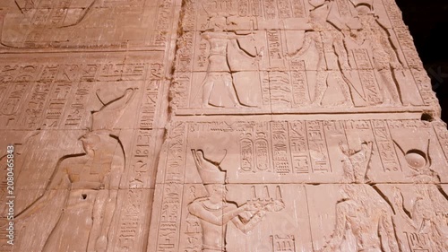 Close up view of intricate ancient Egyptian hieroglyphics and carvings on the stone walls of the Temple of Edfu in Egypt.
