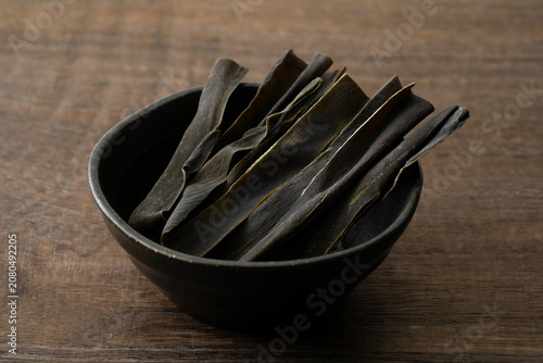 木目背景に小鉢に入れたおしゃぶり昆布