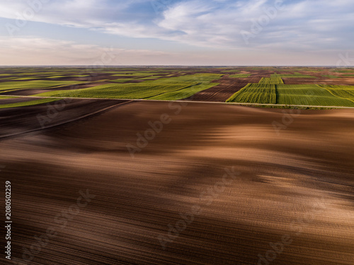 Fényképezés Aerial view showing patterned agricultural fields and ploughed soil
