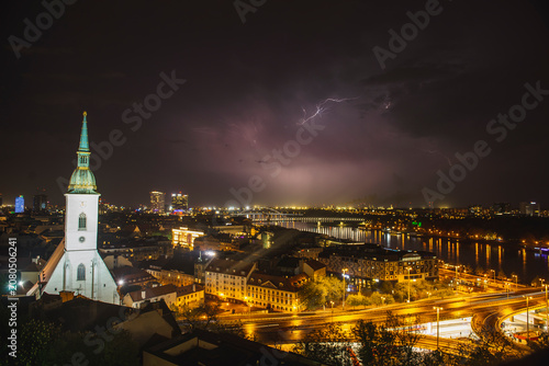 Photography Dramatic night storm over Bratislava with lightning striking above Danube river