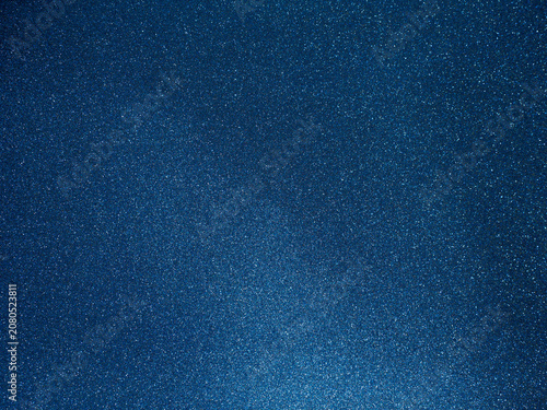 Dark blue sparkling glitter texture background. Abstract starry night sky or galaxy space concept. Shimmering cosmic stardust surface