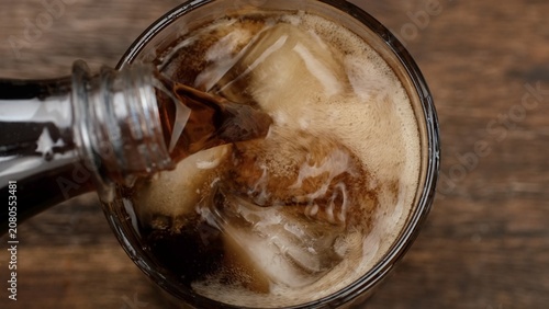 Refreshing drinks. Pouring drinks in glass with ice, top view