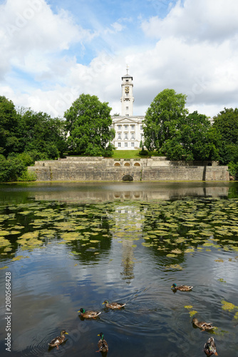 Trent Building And Clock Tower Reflected In The Lake With Ducks Swimming In Highfields Park, Nottingham, England On A Sunny Summer Day.