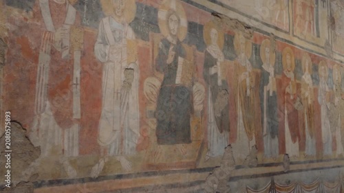 Medieval Frescoes on Weathered Brick Wall Inside Historic Roman Church
