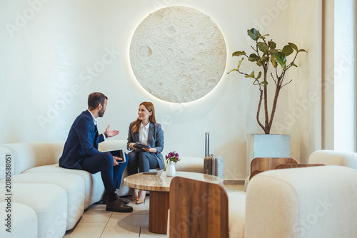 Business Colleagues Having a Friendly Meeting in a Modern Hotel Lobby With Luggage and Documents