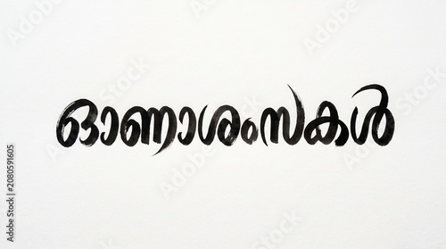 Traditional Black Ink Malayalam Brush Calligraphy Text Reading Onashamsakal for Happy Onam Festival Greetings, Isolated on Clean White Background with Ample Copy Space