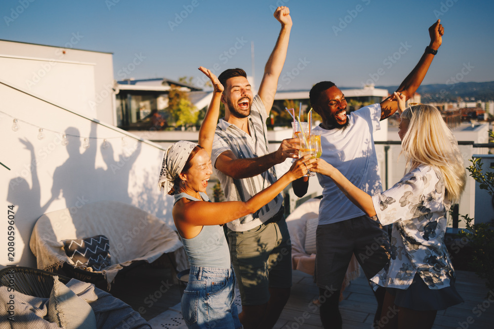 Fototapeta premium Friends celebrating rooftop party, making a toast outdoors