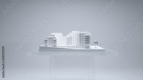 White architectural scale model of a modern residential apartment complex on a clear glass table against a gray background