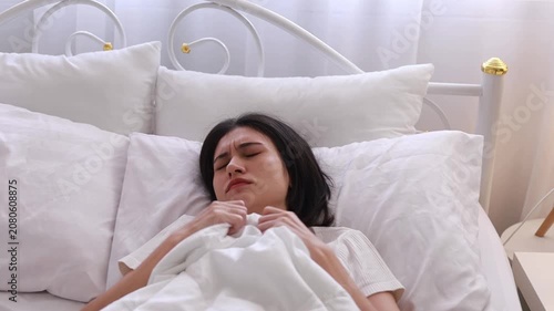 A young woman experiencing nightmares while sleeping in her bedroom at home in the morning could be caused by headaches, migraines, insomnia, sleep apnea, or stress.