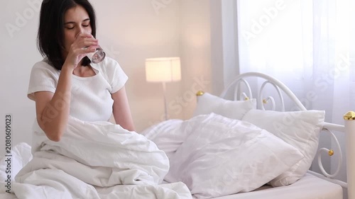 A woman waking up and drinking plain water for good health in the morning. A health-conscious idea.