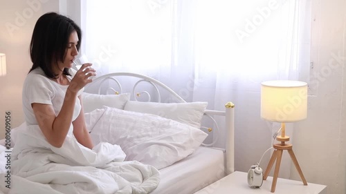 A woman waking up and drinking plain water for good health in the morning. A health-conscious idea.