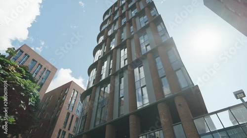 Bottom view of a modern brick building with mirrored windows