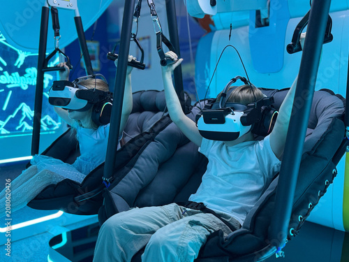 Children using virtual reality headsets together in futuristic gaming center
