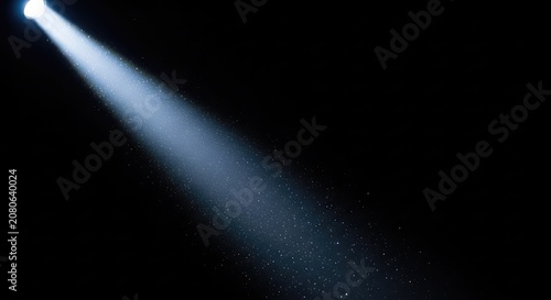A dramatic single bright spotlight beam shines through a dark empty space, illuminating tiny floating dust particles in the sharp rays, design, texture, void