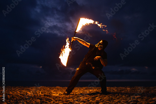 Fire performer with burning torches at night
